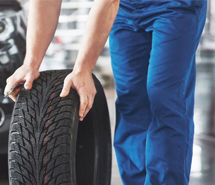Güneş Oto Lastik ustası yeni lastiği montaja taşıyor